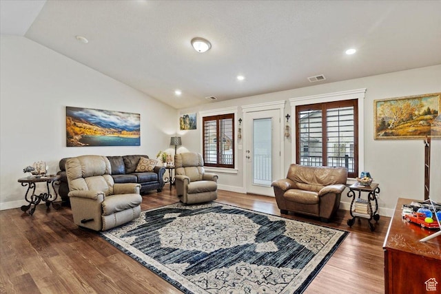 living area featuring dark wood-style flooring, visible vents, and lofted ceiling