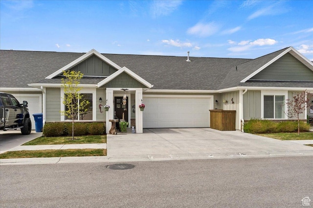 view of front of property with concrete driveway, roof with shingles, board and batten siding, and a garage