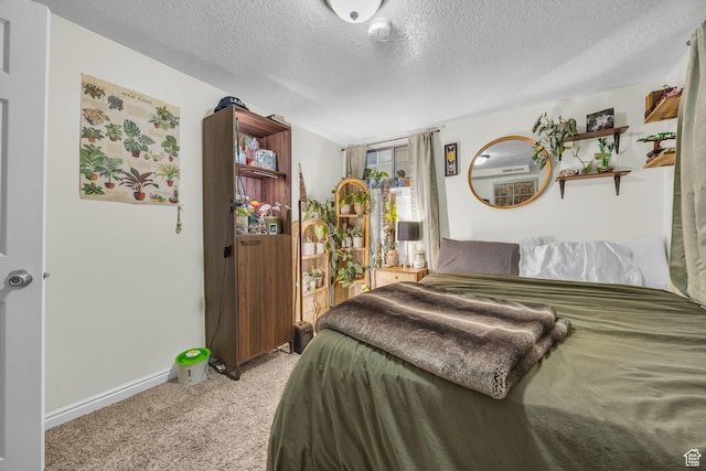 bedroom featuring light colored carpet, baseboards, and a textured ceiling
