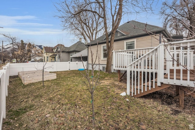 view of yard featuring stairway, a fenced backyard, a deck, and a vegetable garden