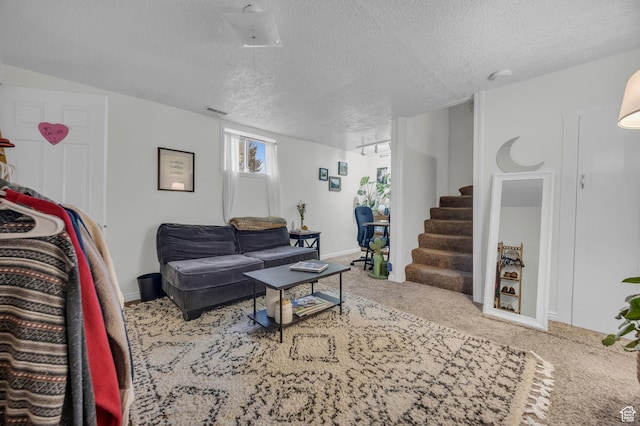 carpeted living room featuring visible vents, baseboards, stairway, and a textured ceiling