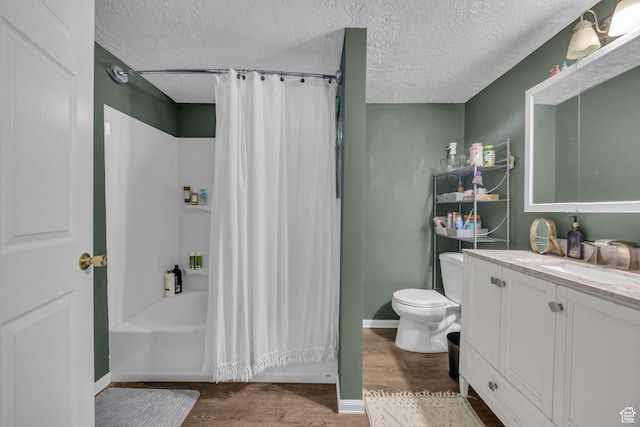 bathroom with toilet, a textured ceiling, wood finished floors, and vanity
