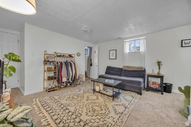 living area with baseboards, carpet, and a textured ceiling