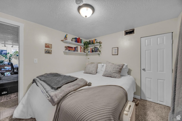 carpeted bedroom featuring a textured ceiling