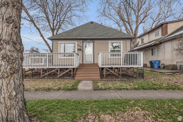 bungalow with roof with shingles and a deck
