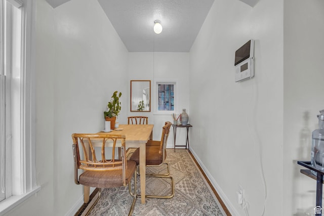 dining area featuring baseboards and a textured ceiling