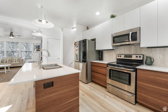 11407 S Oswego Ln, South Jordan, UT 84009 - kitchen with light wood-style floors, appliances with stainless steel finishes, a sink, and white cabinets