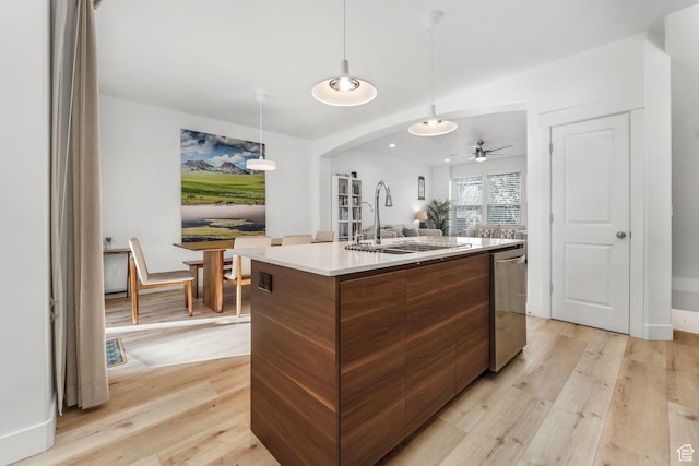11407 S Oswego Ln, South Jordan, UT 84009 - kitchen featuring arched walkways, dishwasher, modern cabinets, an island with sink, and light wood-style floors