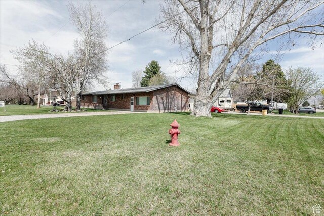 95 S 200 W, Lewiston, UT 84320 - view of front of property featuring brick siding, a chimney, and a front lawn