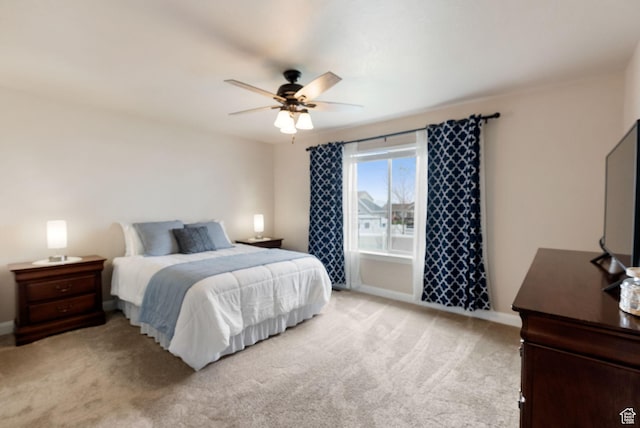 bedroom featuring baseboards, ceiling fan, and light colored carpet
