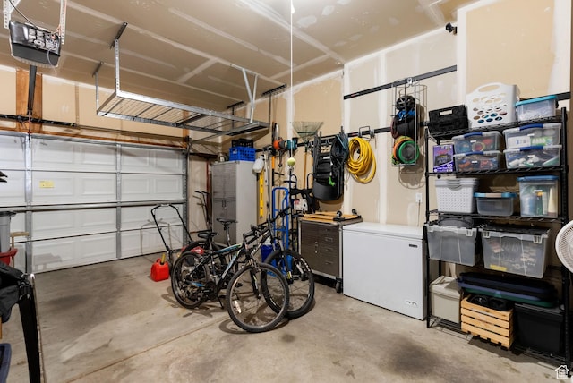 garage featuring white refrigerator and a garage door opener