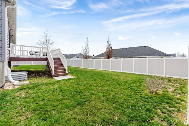 view of yard with fence, a deck, and stairs