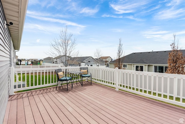 wooden terrace with a residential view and a fenced backyard