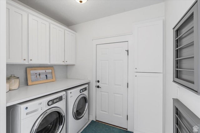 washroom with cabinet space and washing machine and dryer