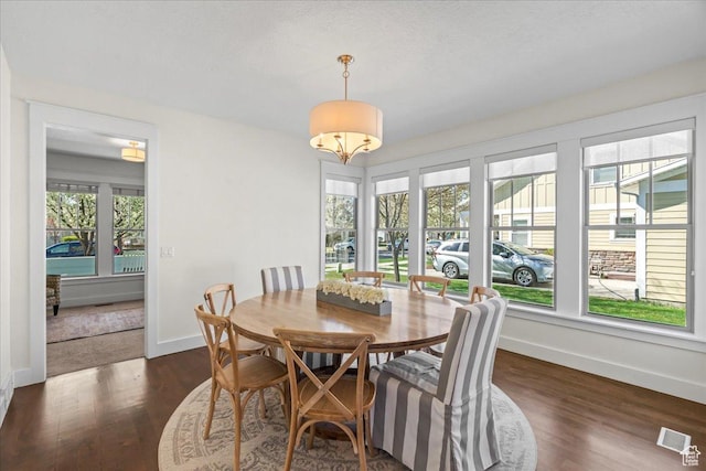 dining area with dark wood-style flooring, baseboards, and visible vents