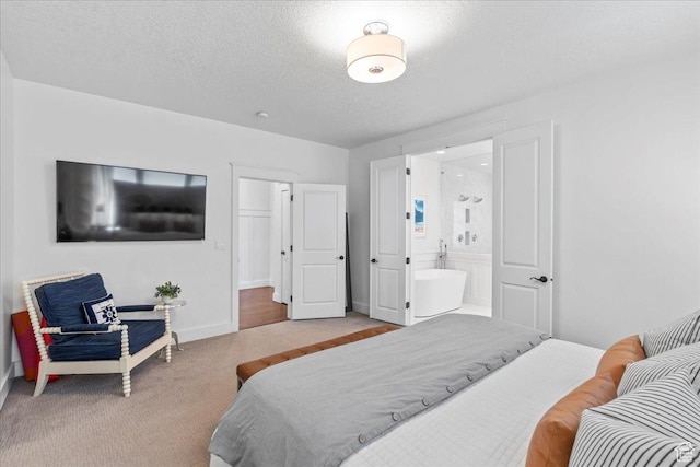 bedroom with baseboards, carpet flooring, ensuite bath, and a textured ceiling
