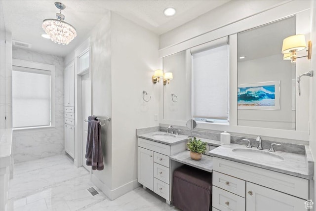 bathroom featuring baseboards, double vanity, an inviting chandelier, marble finish floor, and a sink