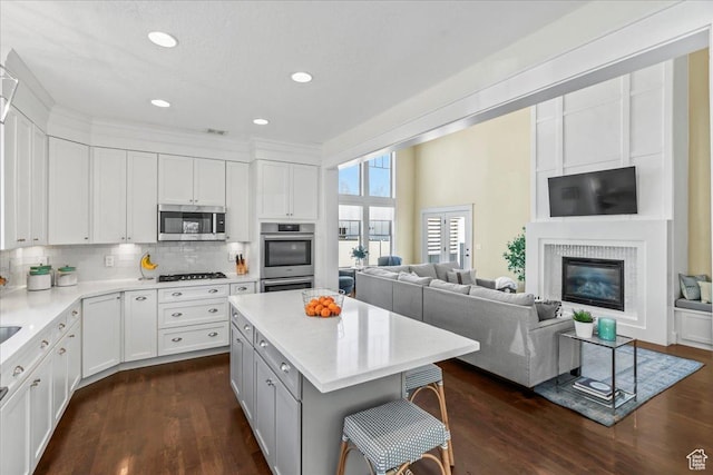 kitchen featuring backsplash, appliances with stainless steel finishes, dark wood finished floors, and white cabinets