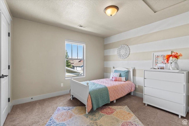 carpeted bedroom featuring a textured ceiling, baseboards, and visible vents