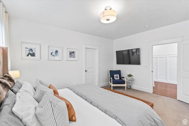 carpeted bedroom with baseboards and a textured ceiling