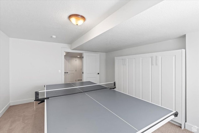 game room with baseboards, light colored carpet, and a textured ceiling
