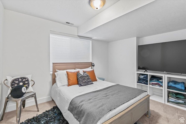 carpeted bedroom with visible vents and a textured ceiling