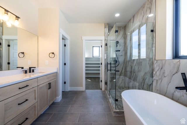 2899 E Lake Dr, Eagle Mountain, UT 84005 - bathroom with a soaking tub, vanity, a stall shower, baseboards, and tile patterned floors