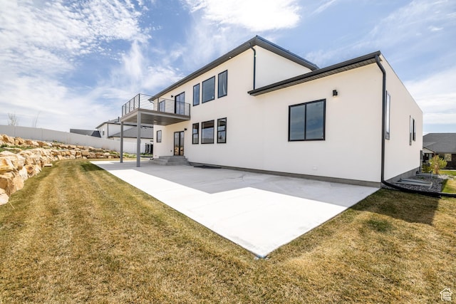 2899 E Lake Dr, Eagle Mountain, UT 84005 - rear view of house featuring a yard, stucco siding, a patio area, fence, and a balcony
