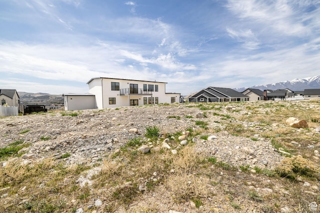 2899 E Lake Dr, Eagle Mountain, UT 84005 - view of front facade with a mountain view, stucco siding, and a balcony