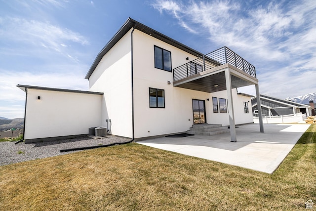 2899 E Lake Dr, Eagle Mountain, UT 84005 - rear view of property with stucco siding, a patio, a lawn, and a balcony