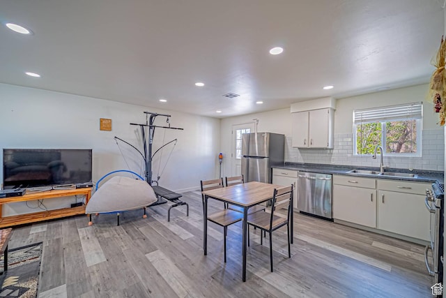 524 Westwood Ave, Moab, UT 84532 - kitchen with dark countertops, a sink, light wood-type flooring, and stainless steel appliances