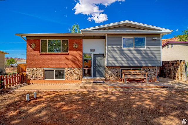 524 Westwood Ave, Moab, UT 84532 - raised ranch featuring a patio, stone siding, and fence