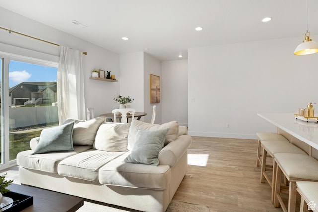 living area featuring light wood-style flooring, recessed lighting, and baseboards