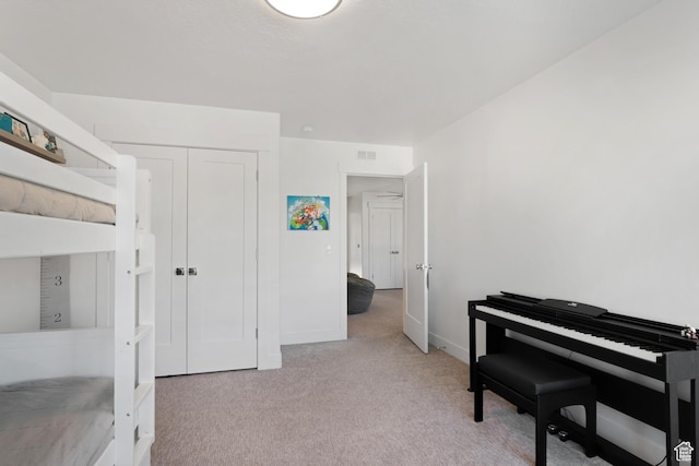 bedroom with light carpet, baseboards, and a closet