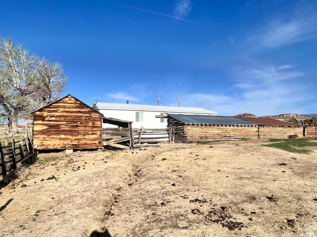 back of property featuring an outbuilding and fence