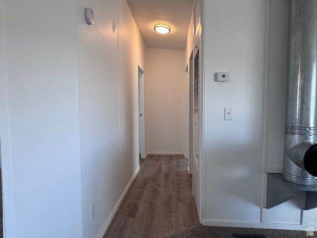 hallway featuring wood finished floors and baseboards