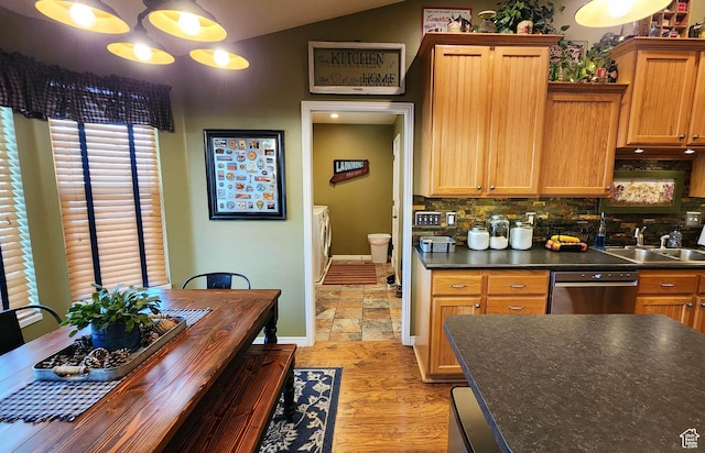 6723 W Hunter Farm Cir S, West Valley City, UT 84128 - kitchen with independent washer and dryer, a sink, dark countertops, backsplash, and lofted ceiling
