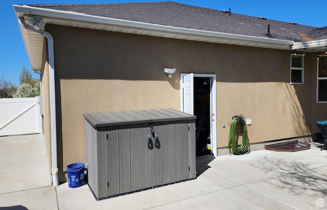 6723 W Hunter Farm Cir S, West Valley City, UT 84128 - entrance to property featuring a patio, stucco siding, a gate, and a shingled roof