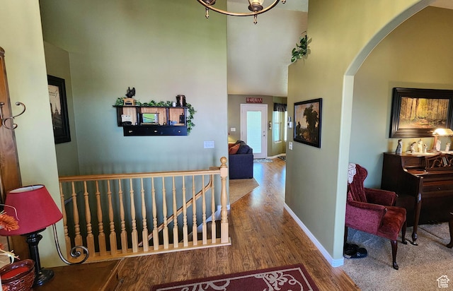 6723 W Hunter Farm Cir S, West Valley City, UT 84128 - hallway with arched walkways, wood finished floors, an upstairs landing, a towering ceiling, and baseboards