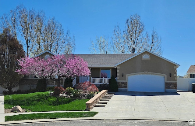 6723 W Hunter Farm Cir S, West Valley City, UT 84128 - view of front of property featuring a garage, stone siding, stucco siding, concrete driveway, and a front lawn
