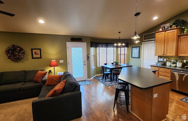 6723 W Hunter Farm Cir S, West Valley City, UT 84128 - kitchen with dark countertops, open floor plan, wood finished floors, stainless steel dishwasher, and vaulted ceiling