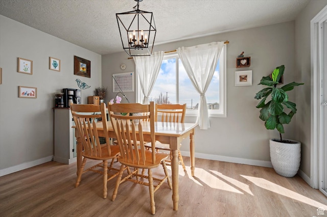 1308 Gilman Dr, Layton, UT 84040 - dining area featuring baseboards, a notable chandelier, wood finished floors, and a textured ceiling