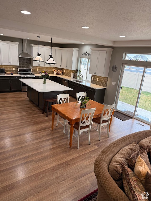 dining area with a textured ceiling, visible vents, wood finished floors, and recessed lighting