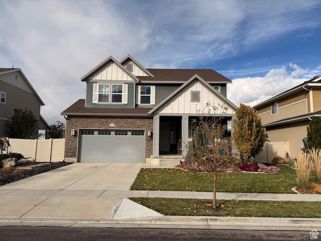craftsman-style home featuring board and batten siding, fence, an attached garage, concrete driveway, and a front yard