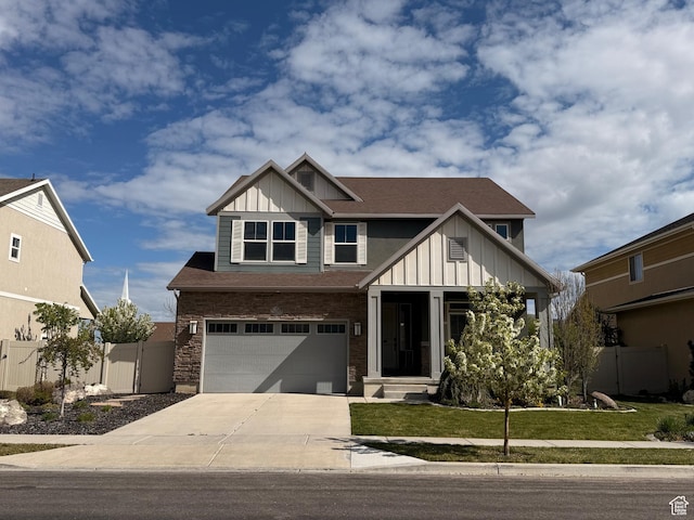 view of front facade with an attached garage, fence, a front lawn, board and batten siding, and driveway
