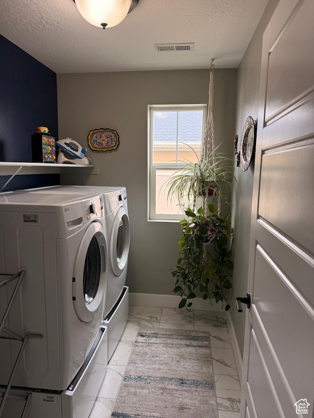 laundry room with laundry area, washing machine and clothes dryer, visible vents, baseboards, and marble finish floor