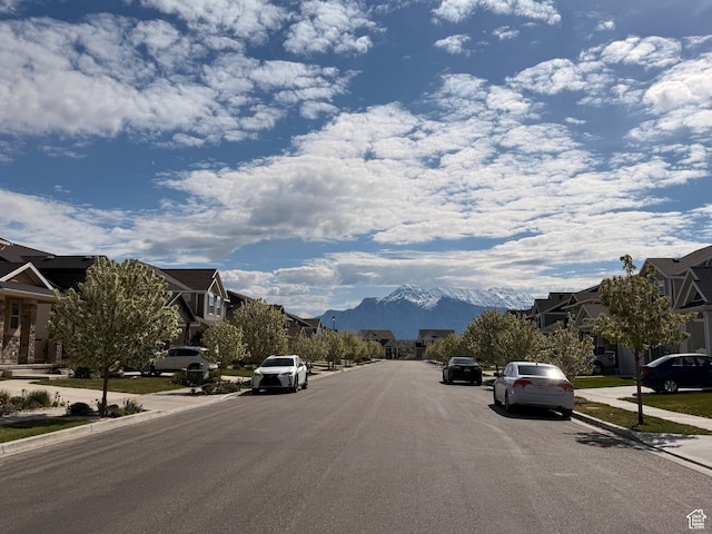 view of road with a mountain view, a residential view, curbs, and sidewalks