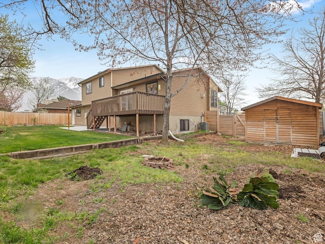 rear view of house featuring fence, a deck with mountain view, stairs, and an outdoor fire pit