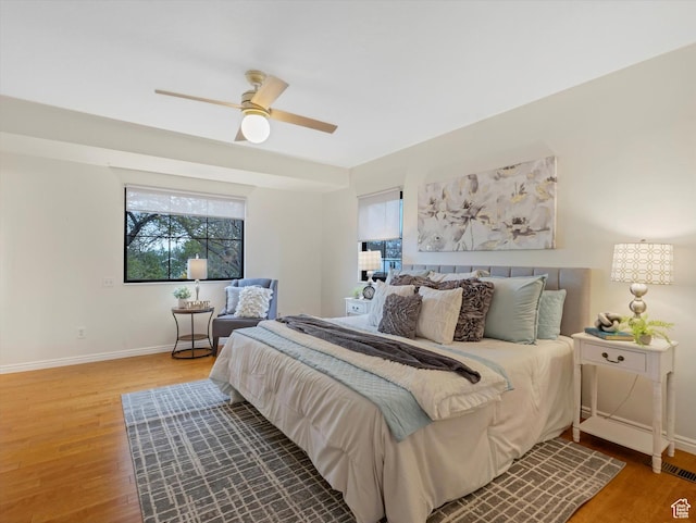 bedroom with baseboards, wood finished floors, and ceiling fan