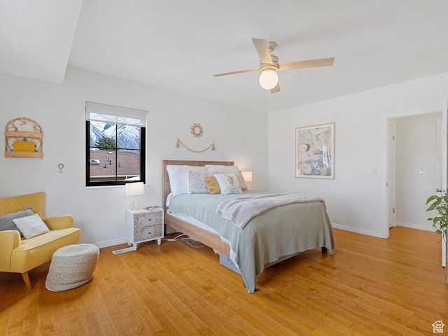 bedroom with light wood-type flooring, visible vents, baseboards, and ceiling fan